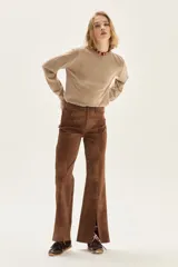 Sweater de punto color beige, con cuello redondo, manga larga y puños acanalados.