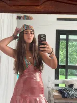 Vestido corto negro con estampado de plumas doradas, escote en V, breteles finos cruzados en la espalda, cut-outs laterales y volado en el ruedo.