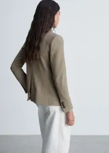 Chaqueta entallada de corte clásico con estampado de micro pata de gallo en tonos tierra. Presenta cuello con solapa, cierre frontal de un botón, bolsillos laterales con solapa y manga larga.