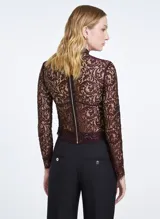 Blusa de encaje color marrón oscuro con hilos metálicos, corte entallado, cuello alto, manga larga, cierre de cremallera trasera y terminaciones efecto deshilachado.