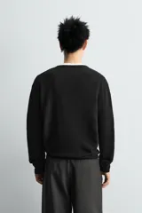 Jersey de punto regular fit, confeccionado en una mezcla de lana y algodón. Presenta cuello redondo, manga larga y terminaciones en rib.