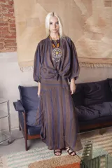 Falda larga de lino con diseño de rayas verticales en tonos marrón y violeta. Presenta un corte con caderín ajustado y un ruedo amplio con cortes dinámicos que aportan movimiento.