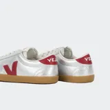 Championes Veja Volley plateados con logo lateral en rojo y suela de goma color caramelo.