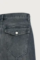 Jeans loose fit de hombre en denim de algodón color gris oscuro con efecto lavado. Presenta perneras con costuras giradas hacia los tobillos, tiro medio, cierre frontal con botones y bolsillos frontales con bolsillo cerillero.