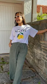 Pantalón de corte ancho y relajado, confeccionado en lino con diseño de rayas verticales. Presenta cintura elástica con cordón de ajuste y bolsillos laterales.