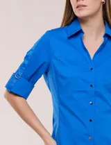 Camisa roja de poplín de algodón, de silueta semi entallada con cuello camisero y escote en V. Cuenta con cierre frontal de botones metálicos, bolsillos plaqué en el pecho y mangas 3/4 arremangables con presilla y argolla metálica.