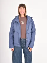 Campera acolchada de color azul, con diseño de costuras en rombos, cierre frontal, capucha y bolsillos delanteros amplios.