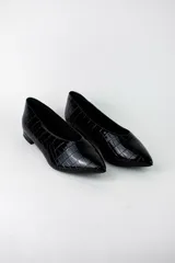 Zapatos planos estilo chatitas marca Marí, modelo Rita, color negro con textura efecto cocodrilo y acabado charol. Tienen punta fina y un diseño clásico de corte bajo.