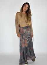 Pollera larga de tiro alto con estampado abstracto en tonos grises y marrones.