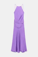Vestido midi de satén color lila, con cuello halter y tirantes finos. Presenta un detalle de nudo en la cintura y espalda descubierta.