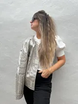 Chaqueta negra de cuero sintético con tachas plateadas, lentejuelas y strass.