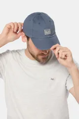Gorro con visera de lona azul marino, con parche rectangular bordado en el frente.