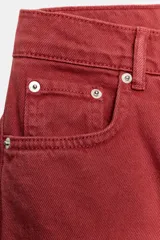 Jeans capri de tiro medio y pernera balloon, color rojo ladrillo. Confeccionados en denim, cuentan con trabillas en la cintura, bolsillos delanteros y traseros, y cierre frontal con cremallera y botón metálico.