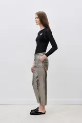 Pantalon de corte recto confeccionado en cuero ovino con acabado metalizado en color plata. Presenta cierre frontal con cremallera y bolsillos laterales.