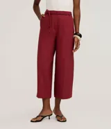 Pantalón modelo pantacourt de corte sastre, color negro, con cintura elástica y lazo ajustable. Confeccionado en tejido de viscosa con caída fluida y diseño de pierna ancha a media pantorrilla.