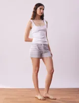 Conjunto de pijama de dos piezas marca René Rofé, compuesto por un top blanco de breteles finos y un short gris con rayas horizontales blancas, cintura elastizada y cordón de ajuste.
