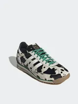 Championes Adidas Originals SL 72 OG con estampado de vaca en blanco y negro, con las tres tiras blancas y cordones verdes.