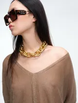 Sweater tipo túnica de tejido liviano con sutil transparencia y acabado brillante. Presenta escote en V, mangas largas relajadas y un corte amplio con largo asimétrico.