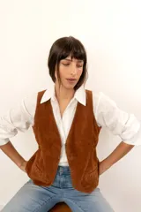 Chaleco marrón de cuero gamuzado con botones metálicos.