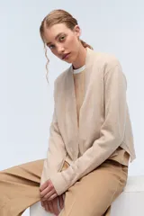 Cardigan de tejido de punto liviano con escote en V y cierre frontal abierto. Presenta puños y bordes acanalados, con un diseño de corte recto y holgado.