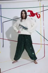 Sweater tejido a mano en lana merino color crudo, con cuello redondo y puños ajustados. Presenta un bordado de una mantis religiosa y la frase "All must dance" en el frente.