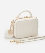 Bolso transversal tipo camera bag, color blanco con textura matelasse de rombos. Tiene correa fina ajustable y removible, cierre de cremallera y colgante de pompón.
