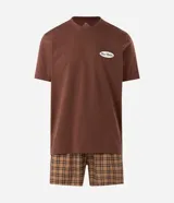 Pijama corto de algodón compuesto por una remera marrón de manga corta con cuello redondo y un pequeño estampado ovalado con texto en el pecho, y una bermuda con diseño a cuadros en tonos marrones y beige.
