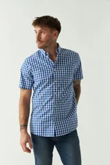 Camisa de manga corta con estampado de cuadros vichy en azul y blanco. Presenta cuello con botones, cierre frontal con botones y logo bordado en el pecho.