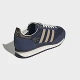 Championes Adidas modelo SL 72, con diseño retro inspirado en los años 70. Presentan un exterior de tela azul marino con revestimientos de gamuza en tono azul más oscuro, detalles en beige en las icónicas tres tiras laterales y una entresuela de EVA con suela dentada.