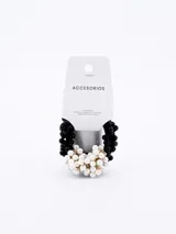 Pack de dos coleros para el cabello. Uno es una goma elástica negra con cuentas negras, y el otro es una goma elástica negra con un racimo de perlas blancas y cuentas doradas.