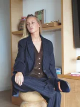 Pantalón de vestir gris con finas rayas verticales, corte palazzo y tiro alto.