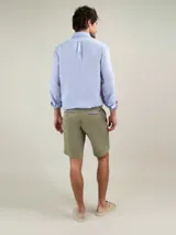 Bermuda de hombre de corte regular fit, color verde militar, confeccionada en mezcla de algodón y elastano. Cuenta con bolsillos laterales y bolsillos traseros.
