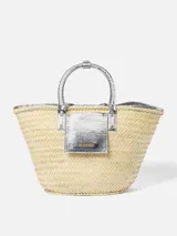 Bolso canasto Jacquemus Le Panier Soli tejido en fibra vegetal con detalles en cuero metalizado plateado, dos asas cortas de mano y bolsillo frontal con logotipo en letras doradas.