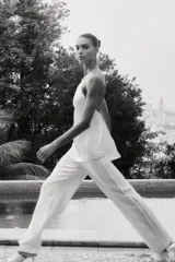 Pantalón de tiro alto color crudo, de pernera recta con detalle de bandas laterales desflecadas.