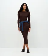 Vestido midi de punto acanalado en color marrón chocolate, con cuello barco y mangas largas. Presenta un corte ajustado al cuerpo y una textura de malla fina.