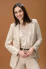 Blazer de corte clásico y estructurado en color marrón con textura de espiga. Presenta solapas tradicionales, cierre frontal y mangas largas.