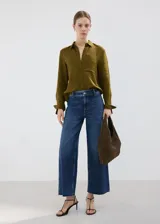 Jeans de corte recto y tiro alto, con diseño de pierna ancha y terminación deshilachada en el ruedo. Presenta un lavado azul clásico con costuras marcadas.