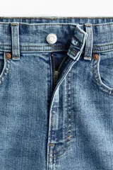 Jean tobillero de cinco bolsillos en denim de mezcla de algodón y viscosa con leve stretch. Piernas amplias, corte estándar de cintura a cadera y corte holgado de muslo a bajo, con cintura de tiro alto, cierre y botón.