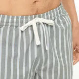 Pack de pijama corto para hombre de dos piezas, compuesto por una remera verde militar de cuello redondo con un bolsillo en el pecho, y un short a rayas verticales en tonos grises y blancos.
