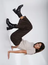 Botas de caña media con acabado charolado brillante, punta cuadrada y taco bloque. Cuentan con cierre lateral interno para facilitar su colocación.