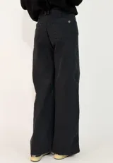 Pantalon de jean negro de corte wide leg, con tiro alto, cierre frontal con botón y bolsillos laterales.