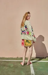 Sweater tejido de lana color crudo, con cuello redondo, puños ajustados y bordado artesanal con figuras de personas tomadas de la mano.