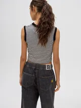 Musculosa crop a rayas horizontales color amarillo y blanco, con cuello redondo rojo y puños negros.