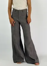 Pantalón de lino azul de corte palazzo, tiro alto y pierna ancha. Presenta costuras a la vista en color blanco y botón metálico.