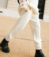 Jogger de frisa color off white, con cintura y puños elásticos, bolsillos laterales y logo bordado en la parte frontal.
