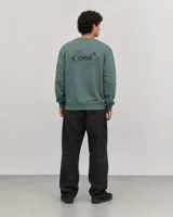 Buzo de cuello redondo en color verde, con diseño de calce holgado, puños y ruedo acanalados, y un pequeño logo bordado en el centro del pecho.