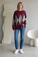 Sweater de tejido de punto con diseño de rombos en contraste, cuello redondo y mangas largas. Presenta una textura suave y un corte holgado.