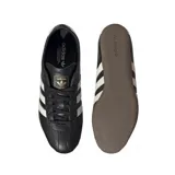 Championes Adidas modelo Tokyo, de cuero negro con las tres bandas laterales en blanco y suela de goma color marrón.