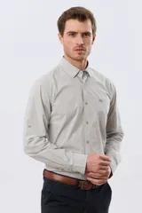 Camisa celeste de manga larga confeccionada en algodón, con cuello camisero, cierre frontal de botones, bolsillo en el pecho y diseño de cuadros sutiles.