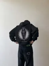 Canguro negro con capucha y bolsillo tipo canguro, confeccionado con felpa suave premium. En la espalda presenta una estampa temática con un esqueleto dentro de un ataúd y las leyendas "Wake Up" y "Kaboa Industries".